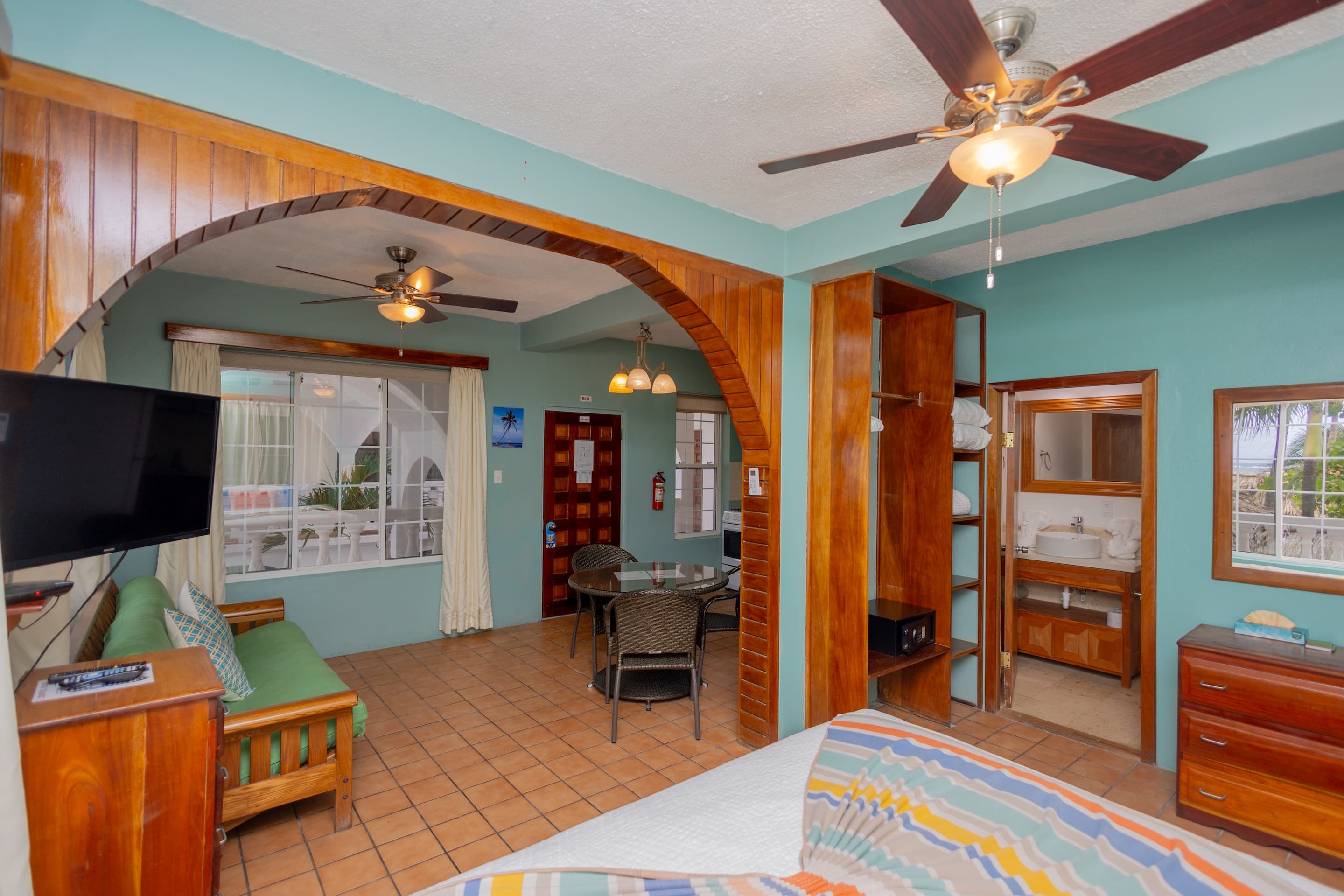 Suite with fully equipped kitchen, dining table, 2 ceiling fans, king bed, futon, large windows with