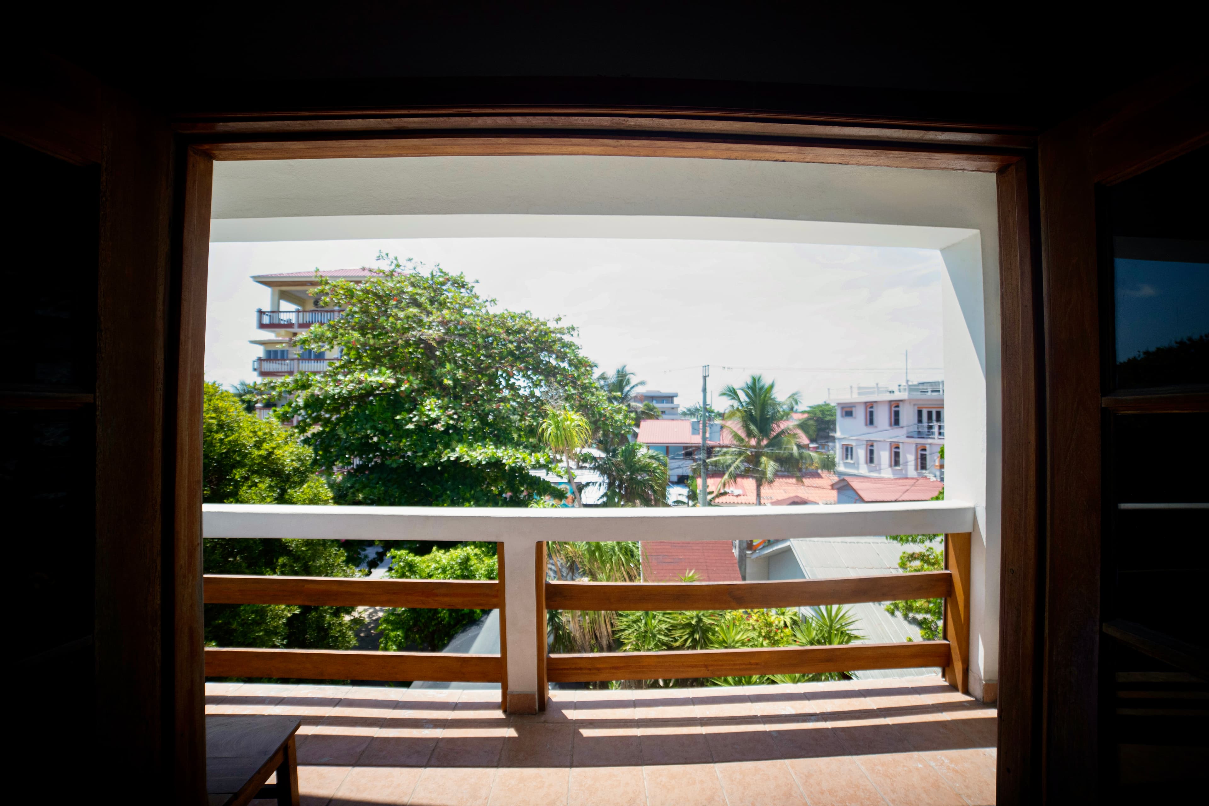 A beautiful resort with white archways and wooden railings surrounds a sparkling turquoise pool, wi