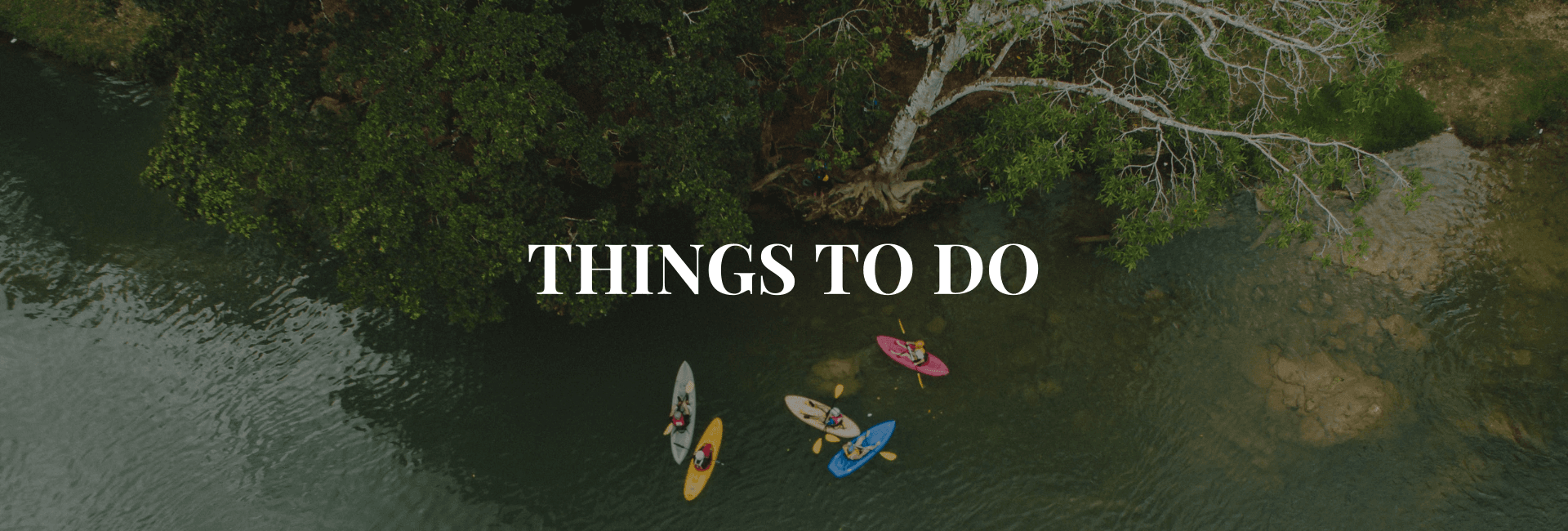 Aerial view of people kayaking on a river surrounded by greenery, with the text "Things to Do" overlayed.