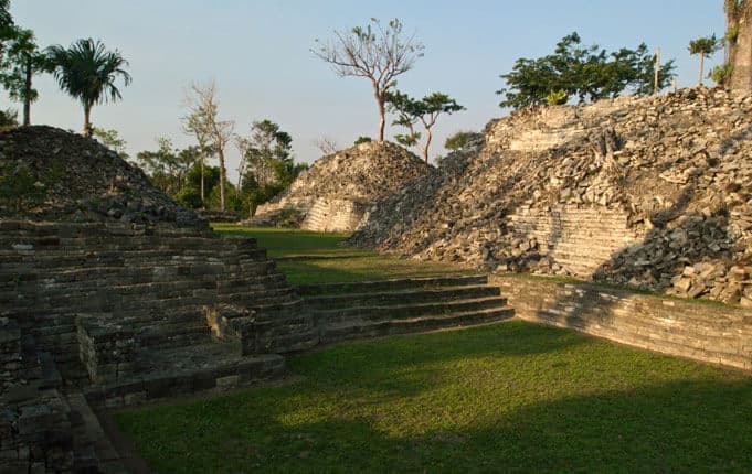 Ancient stone ruins surrounded by lush greenery and trees.